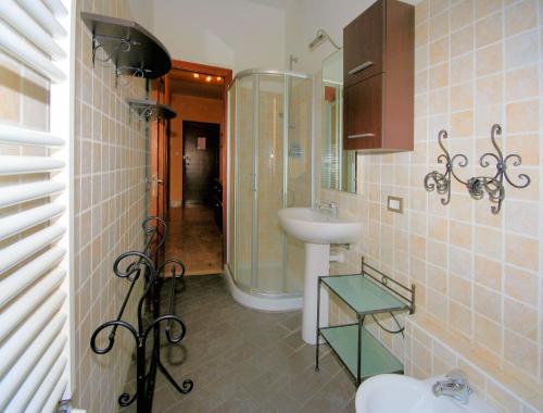ein Bad mit einem Waschbecken und einer Glasdusche in der Unterkunft Aria Di Mare in Borghetto Santo Spirito