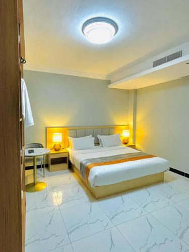 a bedroom with a bed and a table and lights at Abad Hotel in Mogadishu