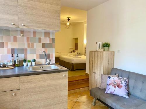 a kitchen with a sink and a room with a bed at Tao House in Taormina