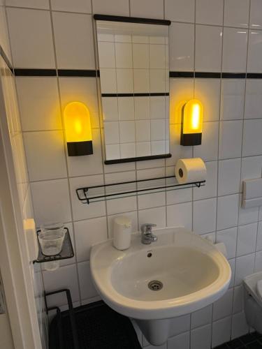 a white bathroom with a sink and a mirror at Chalet Makkum V10 in Makkum