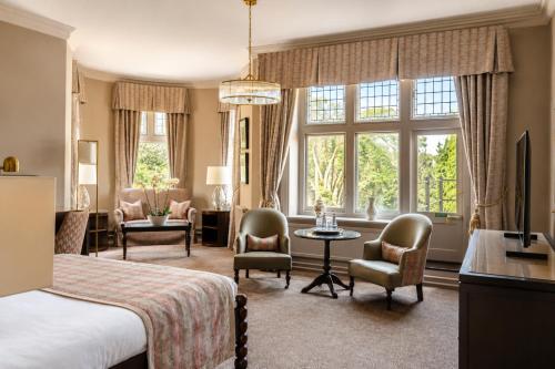 a bedroom with a bed and a living room at Macdonald Berystede Hotel & Spa in Ascot
