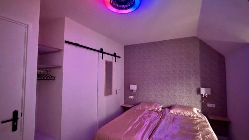 a bedroom with a bed with a pink light on the ceiling at Stationbeds Studio-2 Alkmaar in Alkmaar