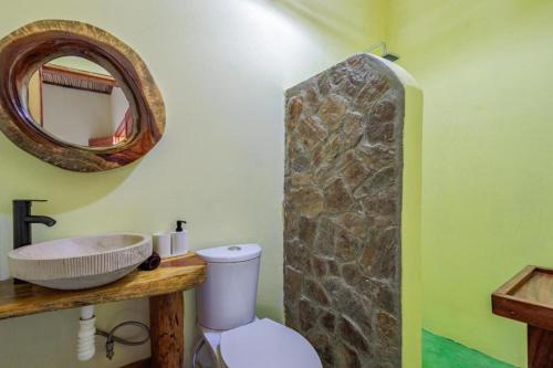 a bathroom with a sink and a stone wall at Hotel Ruunda in San Agustinillo