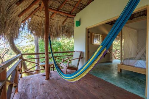 a room with a hammock in a house at Hotel Ruunda in San Agustinillo