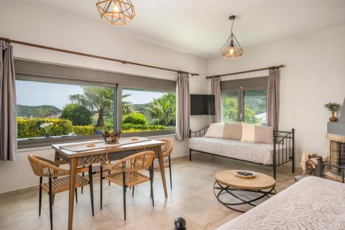 a living room with a table and chairs and a bed at Archontiko Haris in Kolymvari