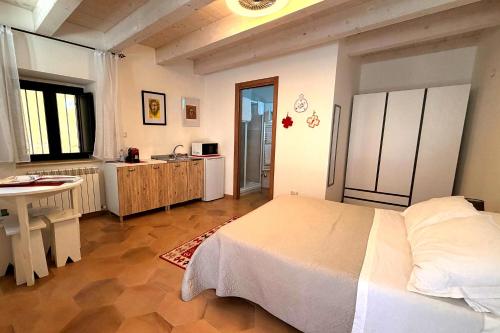 a bedroom with a bed and a table and a kitchen at Your Charming Amantea Getaway in Amantea