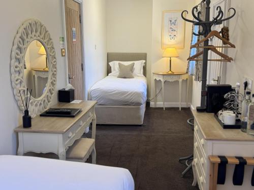 a hotel room with a bed and a mirror at The Old Fourpenny Shop Hotel in Warwick