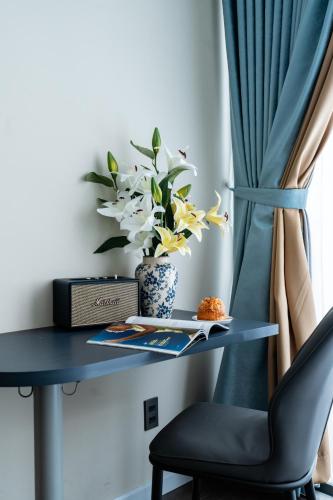 a table with a chair and a vase with flowers at Indochine Casa Hotel in Ho Chi Minh City