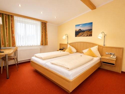 a hotel room with a bed and a desk at Landhotel Kaserer in Bramberg am Wildkogel