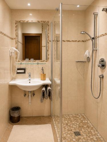 a bathroom with a sink and a shower at Landhotel Kaserer in Bramberg am Wildkogel