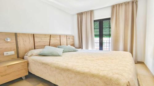 a bedroom with a large bed and a window at Apartamento Aqua by VACAY L'Escala in L'Escala