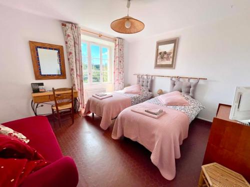 a bedroom with two beds and a table and a chair at Vue sur la Vezere in Treignac