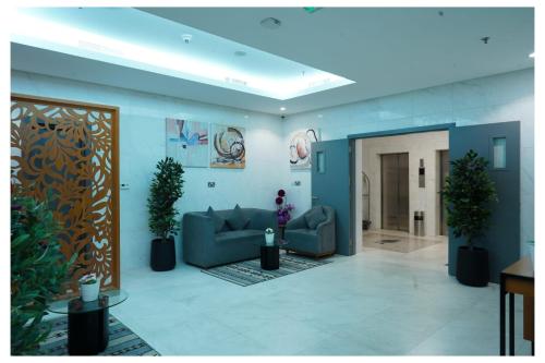 a living room with two couches and potted plants at Saray Prime Suites in Kuwait