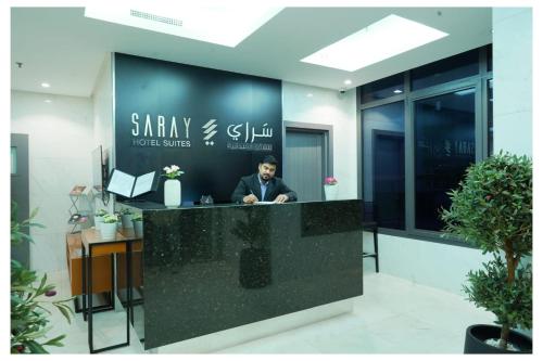 a man sitting at a reception desk in an office at Saray Prime Suites in Kuwait