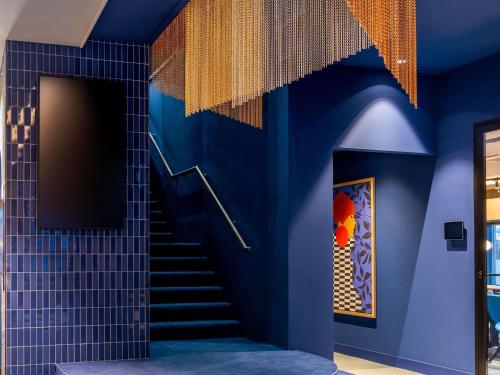 a blue bathroom with stairs and a blue wall at TRIBE Hotel Den Haag Centraal - Opened December 2025 in The Hague