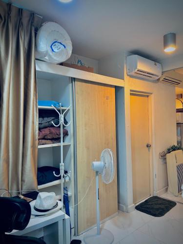 a room with a bed with a fan and a closet at Cozy Poolside Condo Near BTS All Amenities in Sathani Ban Hua Mak