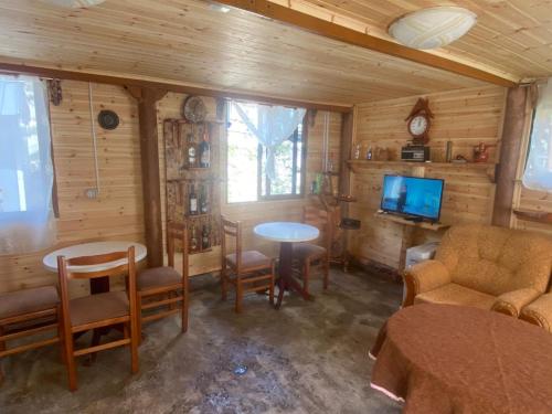 a living room with a tv and a table and chairs at Bujtina Diti in Tropojë