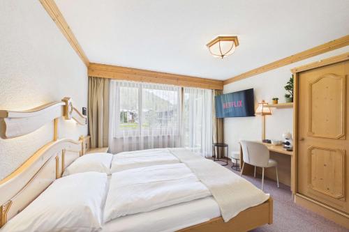 a hotel room with a large bed and a desk at Suite with Mountain View near Saas-Fee in Saas-Almagell