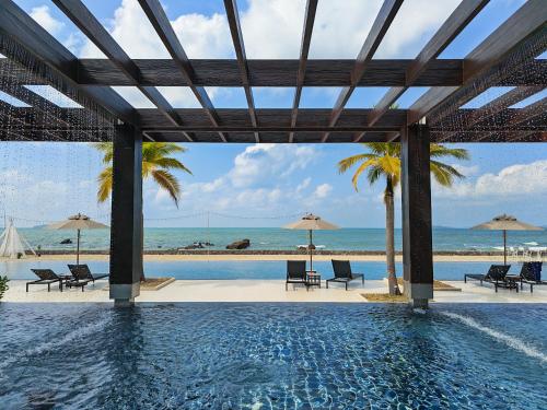 a pool with a view of the beach and the ocean at Beach Penthouse - 3 BR, Jacuzzi, Marriott pool access in Ban Ko Kok