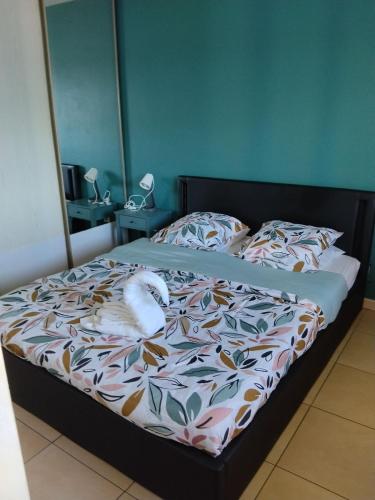 a bed with a white stuffed animal laying on it at Résidence Louis in Saint-Denis