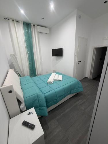 a bedroom with a bed with a blue blanket at B & B Yaya in Taranto