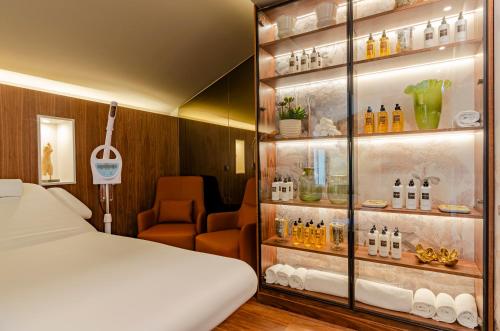 a room with a bed and a shelf with bottles at TURIM Lisboa Hotel in Lisbon