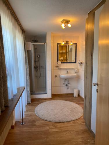a bathroom with a sink and a shower and a mirror at Gästehaus Judith in Längenfeld