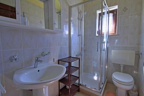 a bathroom with a sink and a toilet and a shower at Guest House Sveti Marko Gacka in Otočac