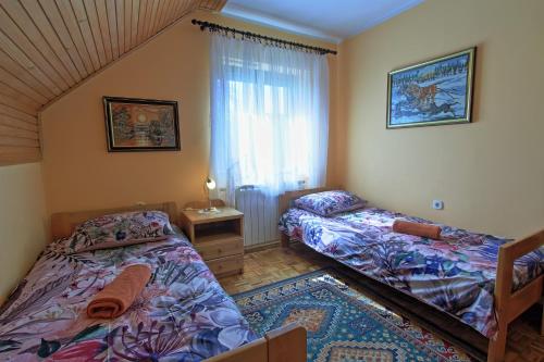 a bedroom with two beds and a window at Guest House Sveti Marko Gacka in Otočac