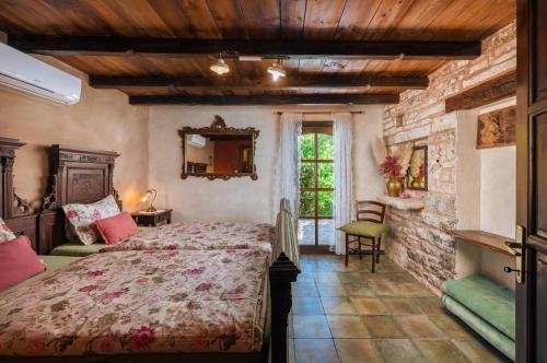 a bedroom with a bed and a stone wall at Casa Karnevali in Žminj