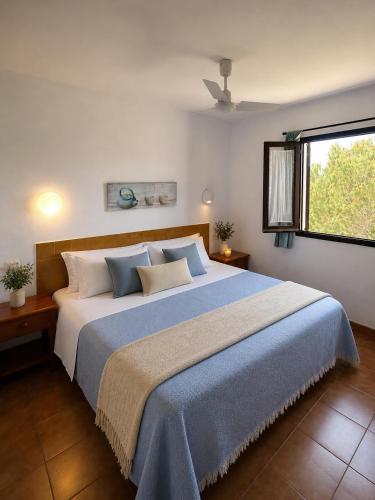 a bedroom with a large bed and a window at Sa Cala C16 in Cala Morell
