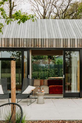 a house with a metal roof on a patio at Boshuis Haen in Ermelo