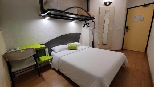 a bedroom with a white bed and a chair at Good Night Hotel in Arques