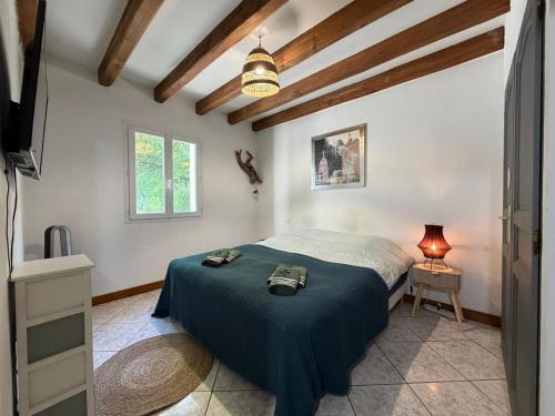 a bedroom with a bed with a blue blanket at La maison d'Artzamendi in Louhossoa