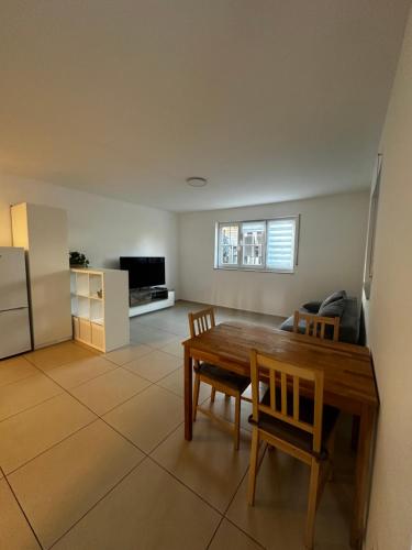 a kitchen and living room with a wooden table and chairs at FEWO Lohmar in Lohmar