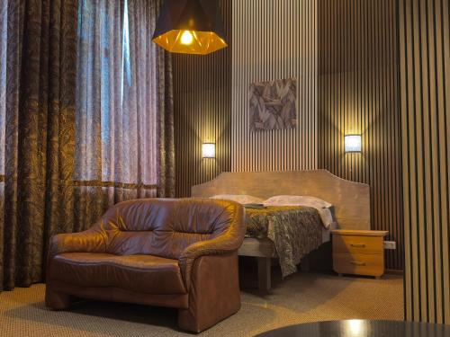 a bedroom with a bed and a chair and a table at GRAND Restaurant&Hotel in Daugavpils