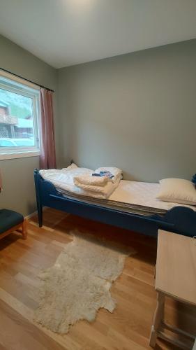 a bed sitting in a room with a rug at Signegarden Bismo in Skjåk