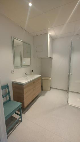 a bathroom with a sink and a green chair at Signegarden Bismo in Skjåk