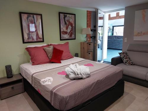 a bedroom with a large bed with pink pillows at Ô Sens Jacuzzi et Massages in Challans
