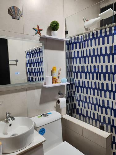 a bathroom with a sink and a toilet and a mirror at Casa Congo Puerto Viejo in Puerto Viejo