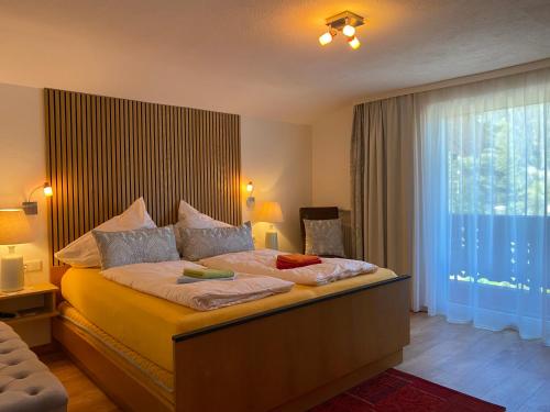 a bedroom with a large bed and a large window at Gästehaus Judith in Längenfeld