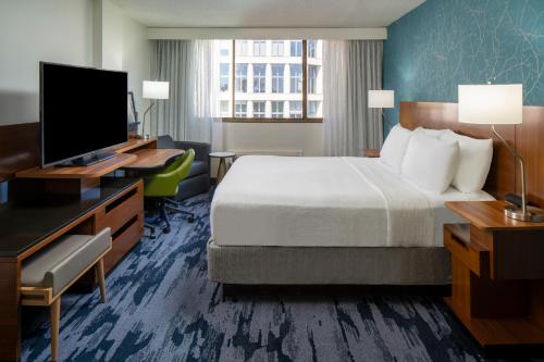 a hotel room with a bed and a flat screen tv at Fairfield Inn & Suites by Marriott Charlotte Uptown in Charlotte