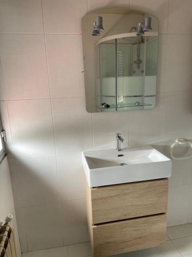 a bathroom with a white sink and a mirror at Casita San Simon in Bayón