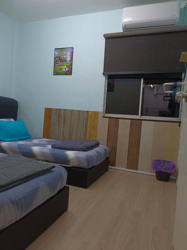 a room with two beds and a window at Kluang Countryside Scenery NO LIFT SECOND FLOOR#NETFLIX#RETRO GAME in Kluang