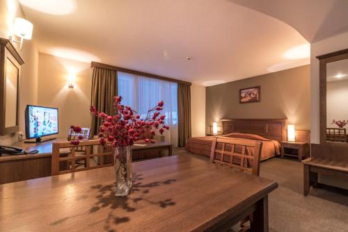 a hotel room with a table with flowers on it at Lion Bansko Hotel in Bansko