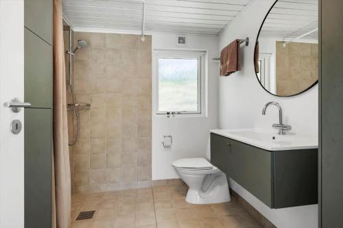 a bathroom with a toilet and a sink and a mirror at 30717-Odder-Alrovej-153 in Amstrup