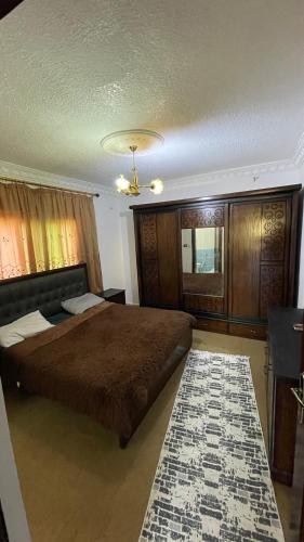 a bedroom with a large bed and a rug at شقة مفروشة in Ajloun