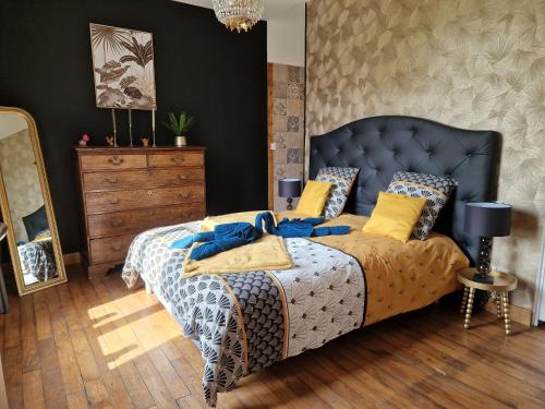 a bedroom with a bed with a blue and yellow comforter at Le Reflet de la Semoy in Les Hautes-Rivières