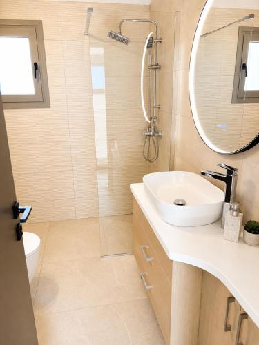 a bathroom with a sink and a mirror at Elysian View Lefkakia in Nafplio