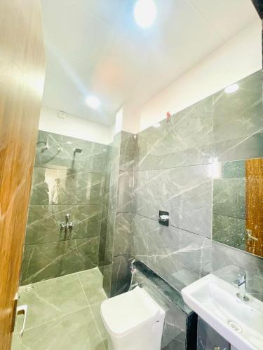 a bathroom with a toilet and a sink at Hotel Nakshatra in Guna